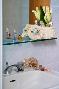 a bathroom sink with a faucet and a shelf at Hotel Hamilton in Misano Adriatico