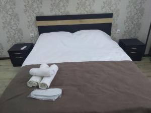 uma cama com duas almofadas e toalhas em Tbilisi apartments em Tbilisi