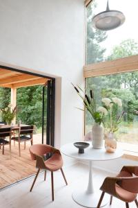 a living room with a table and chairs and a large window at Bosco - Łagów lubuski in Łagów