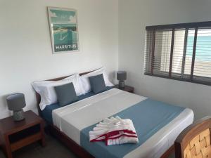 a bedroom with a large bed with blue and white sheets at BEACH VILLA ROCCA in Grand Gaube