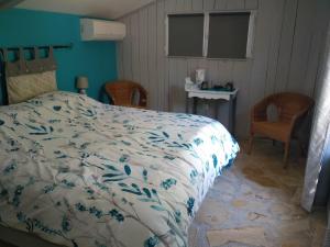 Sainte-Croix-de-QuintillarguesにあるLe clos des olivettesのベッドルーム1室(ベッド1台、テーブル、椅子付)