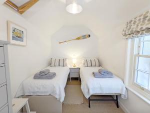two twin beds in a room with a window at Hearnesbrook Barn , Emsworth in Emsworth