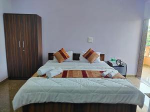 um quarto com uma cama grande com almofadas em The Narrow Way Edward Guest House em Candolim