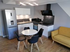 kuchnia ze stołem, krzesłami i kanapą w obiekcie Appartement moderne entièrement rénové w mieście Aurillac
