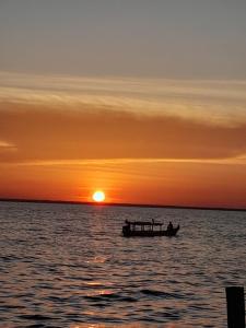 a boat on the water at sunset at Suíte BOTOS DE ALTER in Alter do Chao