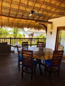 a dining room with a wooden table and chairs at Hotel Bajito Bay in Troncones