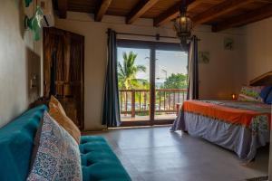 een slaapkamer met een bed en uitzicht op de oceaan bij Hotel Bajito Bay in Troncones