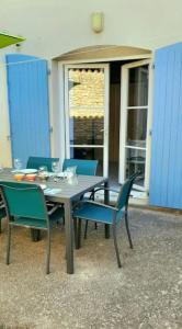 einen Tisch und Stühle auf einer Terrasse mit Tisch und Stühlen in der Unterkunft Délicieux moment de détente au coeur de Saint Martin de Ré in Saint-Martin-de-Ré