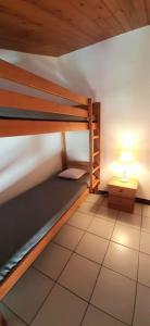ein kleines Zimmer mit 2 Etagenbetten und einer Lampe in der Unterkunft Délicieux moment de détente au coeur de Saint Martin de Ré in Saint-Martin-de-Ré