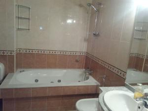ein Badezimmer mit einer Badewanne und einem Waschbecken in der Unterkunft Piso in Boiro