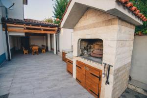 eine Außenküche mit einem Pizzaofen auf einer Terrasse in der Unterkunft Holiday Home My Dream in Šibenik