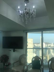 ein Wohnzimmer mit 2 Stühlen und einem Flachbild-TV in der Unterkunft Beach front Apartament in Cartagena de Indias