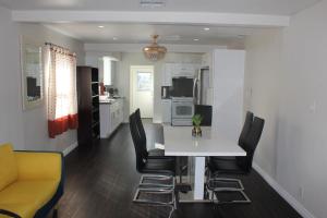 a kitchen with a white table and black chairs at Entire 3 Bedroom Home with Golf Putting & hot spa in Los Angeles