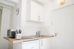 a white kitchen with a sink and a microwave at Nouveau - AuPetitSaumur in Saumur