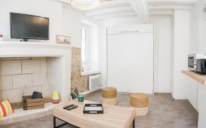 a living room with a fireplace and a tv at Nouveau - AuPetitSaumur in Saumur