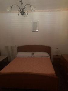 1 dormitorio con cama y lámpara de araña en Le camere di aisa, en Santa Maria degli Angeli