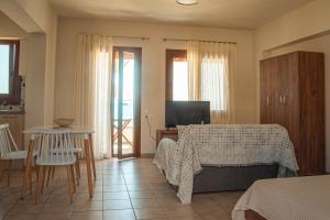 a bedroom with a bed and a table and a television at Apartment by the sea in Stalida
