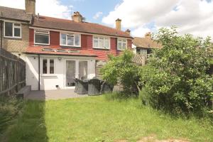 a house with a patio in the yard at Knollmead House in Surbiton