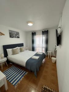 een slaapkamer met een bed en een televisie. bij Residencial Mira-Mar in Peniche