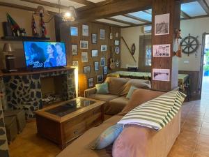a living room with a couch and a tv at Villa Marina in Los Palacios y Villafranca