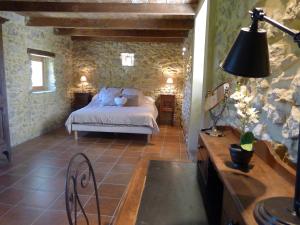 1 dormitorio con 1 cama en una pared de piedra en Domaine de Cousignac, en Bourg-Saint-Andéol