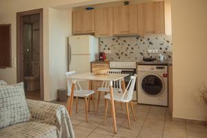 a kitchen with a table and chairs and a refrigerator at Apartment by the sea in Stalida