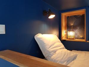 - une chambre dotée d'un mur bleu avec un lit et une fenêtre dans l'établissement Brest : Beau T1 en centre ville, à Brest