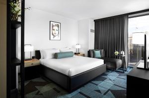 um quarto de hotel com uma cama e uma cadeira em Downtown Grand Hotel & Casino em Las Vegas