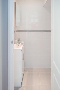 bagno bianco con doccia e lavandino di Knollmead House a Surbiton