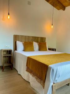 a bedroom with a large bed with a wooden headboard at Finca La Portilla in Aroche