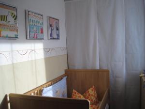 una camera da letto con una culla con cuscini di Haus Janßen-Wehrle a Titisee-Neustadt