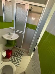 a bathroom with a toilet and a sink and a shower at MonDieu Hostel in Barranquilla