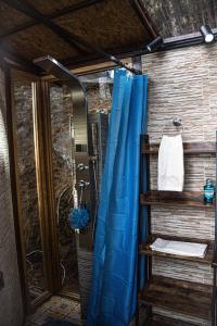 y baño con ducha con cortina azul. en Refugios de Alta Güita, en Suesca