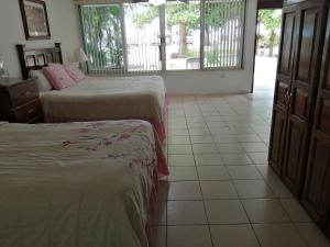 a hotel room with two beds and a balcony at Freedom Shores "La Gringa" Hotel - Universally Designed in Isla Aguada