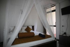 a bedroom with a canopy bed with a window at Rawana Mountain View in Ella