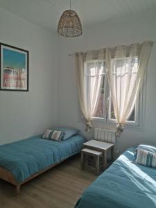 a bedroom with two beds and a window at La Petite Etoile in Andernos-les-Bains