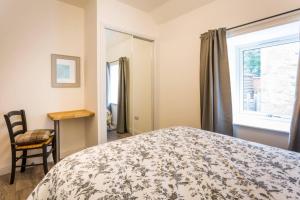 a bedroom with a bed and a window and a chair at Ideal Couples base for exploring the Island in Shiskine