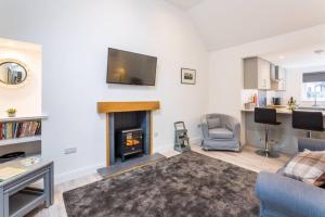 a living room with a fireplace and a tv on the wall at Ideal Couples base for exploring the Island in Shiskine +9 photos