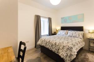a bedroom with a bed and a table and a window at Ideal Couples base for exploring the Island in Shiskine