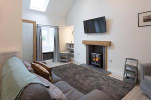 a living room with a couch and a fireplace at Ideal Couples base for exploring the Island in Shiskine