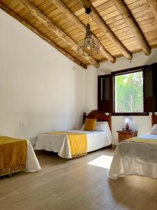 a bedroom with two beds and a window at Finca La Portilla in Aroche