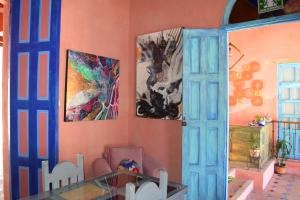 uma sala de jantar com pinturas na parede e uma mesa de vidro em Gran Barrio em San Cristóbal de Las Casas