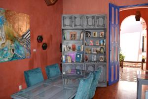 une salle à manger avec une table en verre et des chaises bleues dans l'établissement Gran Barrio, à San Cristóbal de Las Casas