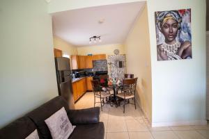 a living room with a table and a kitchen at Nickels Garden Villas in Montego Bay