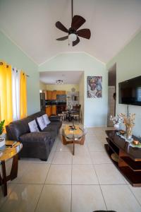 a living room with a couch and a ceiling fan at Nickels Garden Villas in Montego Bay