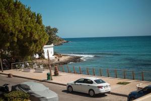 a white car parked next to the ocean at Apartment by the sea in Stalida
