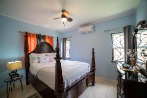 1 dormitorio con 1 cama en una habitación con paredes azules en Nickels Garden Villas en Montego Bay