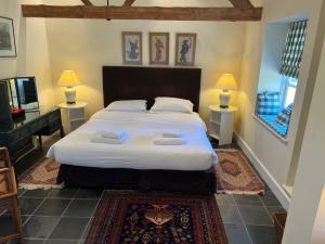 una camera con un grande letto e una televisione di Heath House Farm a Frome