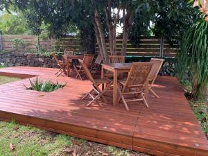 a wooden deck with chairs and a table at appartement 1 avec wifi in Ravine des Cabris