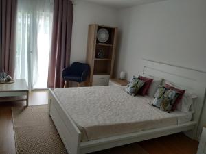 a bedroom with a bed and a blue chair at Brava in Vila Franca do Campo +14 photos
